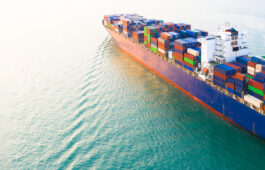 Aerial side view container ship carrying container in import export business logistic and transportation of international by container ship in the open sea, with copy space.